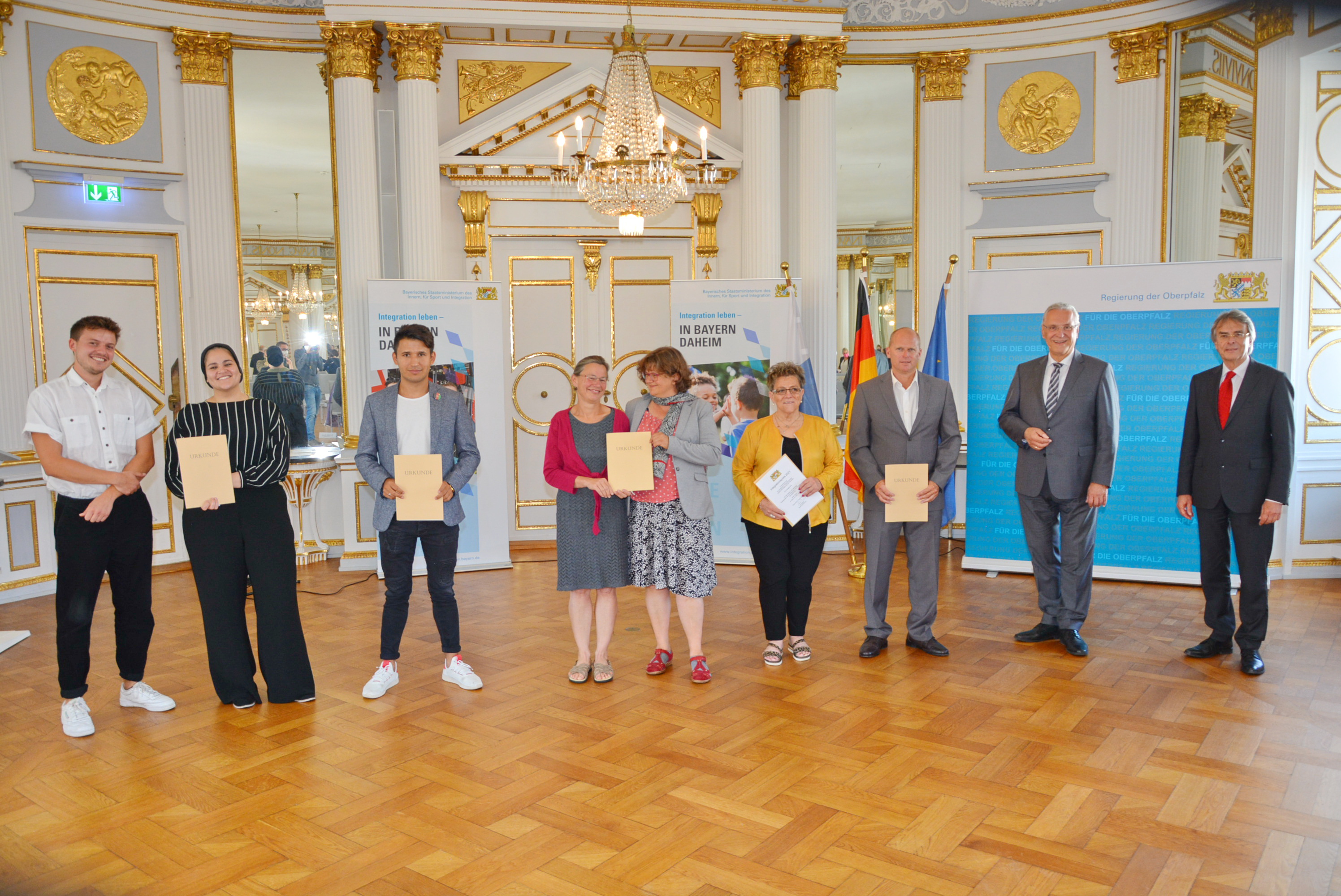 vlnr: Tim Schlierkamp-Voosen und Taqwa Gad vom Verein Migrantenmedizin e.V., 2. Preis beim Integrationspreis der Oberpfalz 2021, Nezamuddin "Karim" Haydari, 3. Preis beim Integrationspreis der Oberpfalz 2021, Alexandra Geiger und Dr. Esther Burkert vom Hilfe für Geflüchtete und Menschen auf der Flucht Regensburg e.V., 1. Preis beim Integrationspreis der Oberpfalz 2021, Brigitte Ertl, 3. Preis beim Integrationspreis der Oberpfalz 2021,Roland Troidl von der Grund- und Mittelschule Ammersricht, 2. Preis beim Integrationspreis der Oberpfalz 2021, Innen- und Integrationsminister Joachim Herrmann, Regierungspräsident Axel Bartelt
Regierung der Oberpfalz/Schmied vlnr: Tim Schlierkamp-Voosen und Taqwa Gad vom Verein Migrantenmedizin e.V., 2. Preis beim Integrationspreis der Oberpfalz 2021, Nezamuddin "Karim" Haydari, 3. Preis beim Integrationspreis der Oberpfalz 2021, Alexandra Geiger und Dr. Esther Burkert vom Hilfe für Geflüchtete und Menschen auf der Flucht Regensburg e.V., 1. Preis beim Integrationspreis der Oberpfalz 2021, Brigitte Ertl, 3. Preis beim Integrationspreis der Oberpfalz 2021,Roland Troidl von der Grund- und Mittelschule Ammersricht, 2. Preis beim Integrationspreis der Oberpfalz 2021, Innen- und Integrationsminister Joachim Herrmann, Regierungspräsident Axel Bartelt
Regierung der Oberpfalz/Schmied