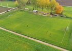 Fußballplatz mit Kindern und Linien von oben, wodurch eine beispielhafte Bebauung gezeigt werden soll.