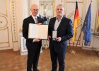 Regierungspräsident Walter Jonas überreicht Bruno Batholomäi die Bayerische Rettungsmedaille.