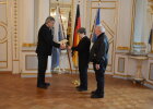 Regierungspräsident Axel Bartelt übergibt die Pflegemedaille an Elisabeth und Hermann Schanzer