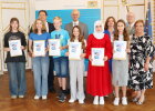 Regierungspräsident Walter Jonas (Mitte hinten), Bezirksheimatpfleger Dr. Tobias Appl (3.v.l.h.), Anette Kreim, Ministerialbeauftragte für die Gymnasien (1.v.r.) und Abteilungsdirektor Thomas Unger (2.v.r.h) mit der ausgezeichneten Schülerinnen und Schülern und der Schulvertretung des Willibald-Gluck-Gymnasiums Neumarkt