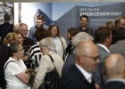 Gäste bei der Ausstellungseröffnung mit Ausstellung im Hintergrund