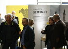 Gäste bei der Ausstellungseröffnung mit Ausstellung im Hintergrund