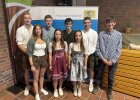 Gruppenfoto von acht jungen Absolventinnen und Absolventen vor einem Roll-Up mit dem Logo der Regierung der Oberpfalz. Einige tragen Tracht, andere legere Kleidung. Das Bild wurde im Rahmen der Freisprechungsfeier in Weiden/Almesbach aufgenommen.