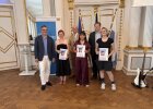 Zwei Preisträgerinnen des Johann-Andreas-Schmeller-Gymnasiums Nabburg präsentieren ihre Urkunden gemeinsam mit einem Lehrer und Vertretern der Regierung.
