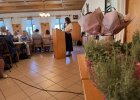 Birgitta Pilz spricht am Rednerpult, im Vordergrund stehen Kräutertöpfe und Blumen.