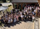 Absolventinnen und Absolventen, Ehrengäste und Begleitpersonen stehen für ein großes Gruppenfoto im Innenhof.