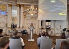Caroline Domani steht im Spiegelsaal der Regierung der Oberpfalz am Rednerpult und spricht vor Publikum bei der Preisverleihung des Kreativwettbewerbs.