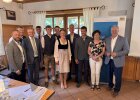 Drei junge Absolventinnen und Absolventen stehen gemeinsam mit Ehrengästen und Vertretern der Landwirtschaft vor einem Roll-up der Regierung der Oberpfalz.